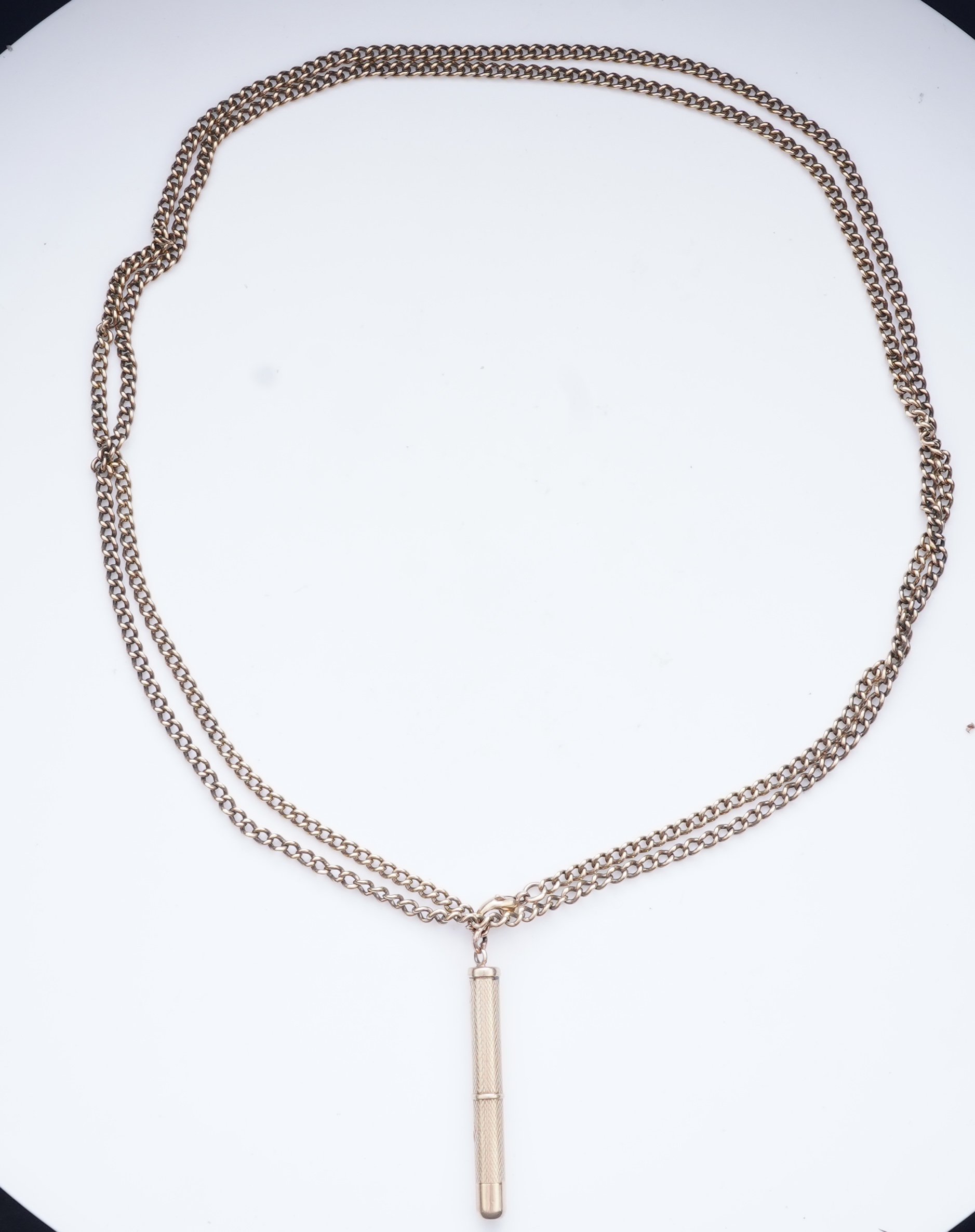 A gold toothpick and chain necklace